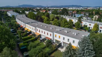 die Wohnhausanlage Tenschertstraße mit kleinen Gärten und Terrassen sowie Flachdächern mit Kiesbestreuung