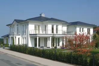 Steildach mit dunklen Dachsteinen von BMI Bramac bei einem Einfamilienhaus mit weißer Fassade